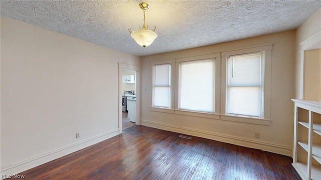 unfurnished room with dark hardwood / wood-style floors and a textured ceiling