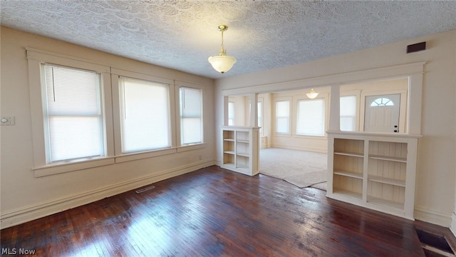 spare room with dark wood-type flooring and a textured ceiling