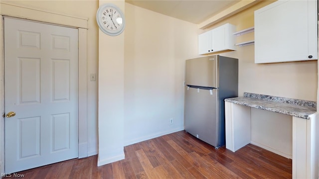 kitchen with stainless steel fridge, dark hardwood / wood-style floors, and white cabinets