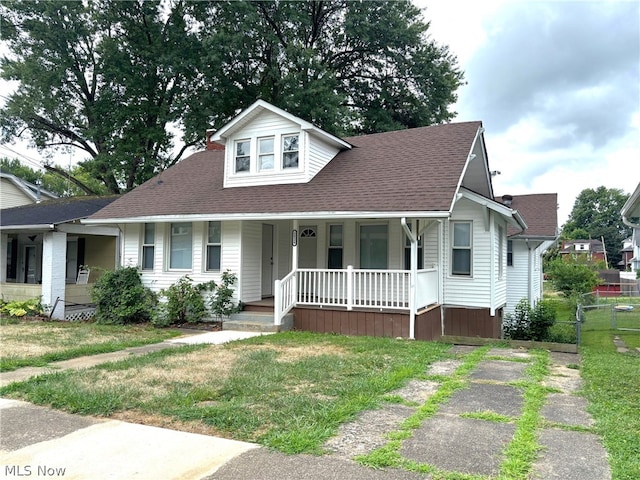 bungalow-style home with a front yard and covered porch