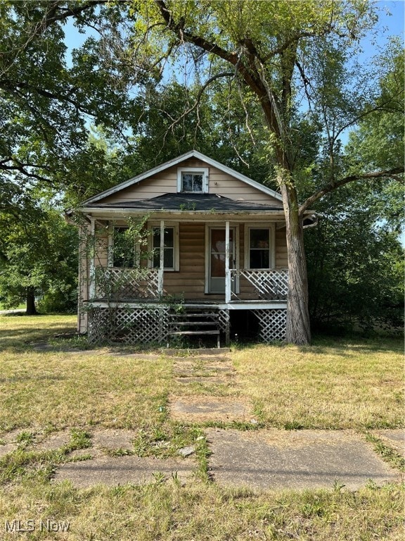 bungalow with a porch and a front lawn