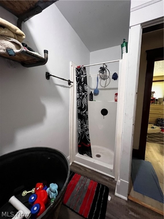 bathroom with walk in shower and wood-type flooring