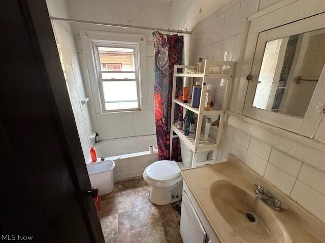 full bathroom featuring shower / bath combination with curtain, vanity, toilet, and tasteful backsplash