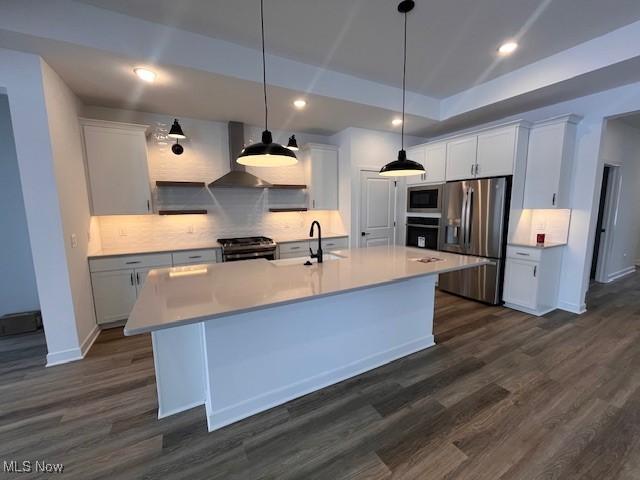 kitchen featuring a raised ceiling, sink, black appliances, decorative light fixtures, and white cabinetry