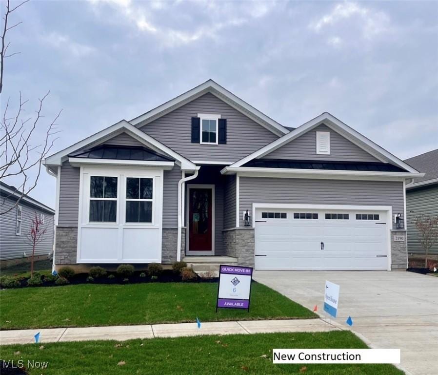 craftsman house with a front yard and a garage