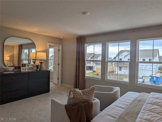 bedroom featuring light colored carpet and a textured ceiling