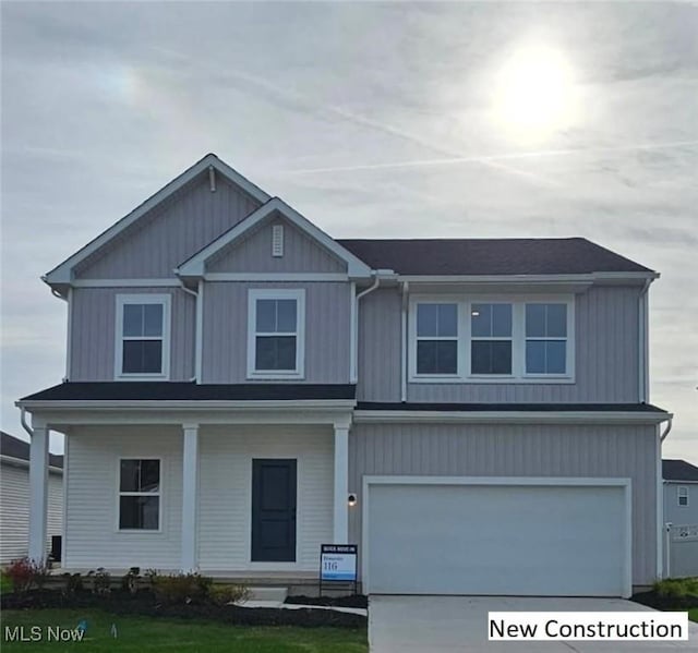 view of front of home with a garage, concrete driveway, and a front lawn