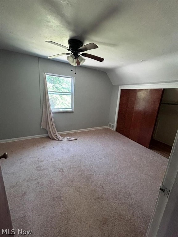 interior space featuring carpet floors, ceiling fan, and vaulted ceiling