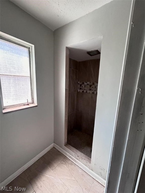 bathroom with a textured ceiling and tile patterned floors