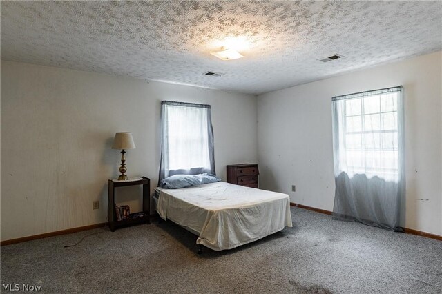 carpeted bedroom with a textured ceiling