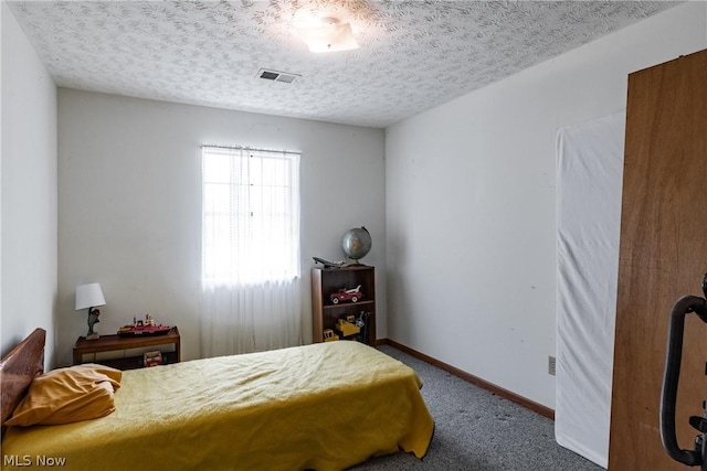 bedroom with carpet floors and a textured ceiling