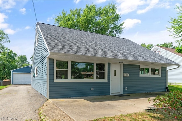 view of front of home featuring a garage and an outbuilding