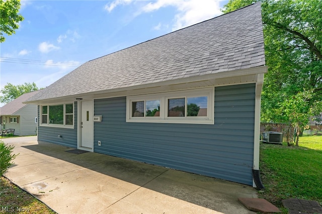 back of property with cooling unit and a yard