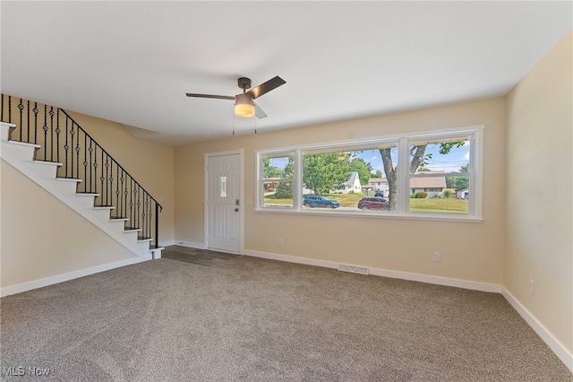 carpeted foyer featuring ceiling fan