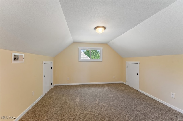 bonus room featuring a textured ceiling, carpet, and vaulted ceiling