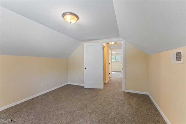 bonus room featuring carpet floors, a textured ceiling, and lofted ceiling