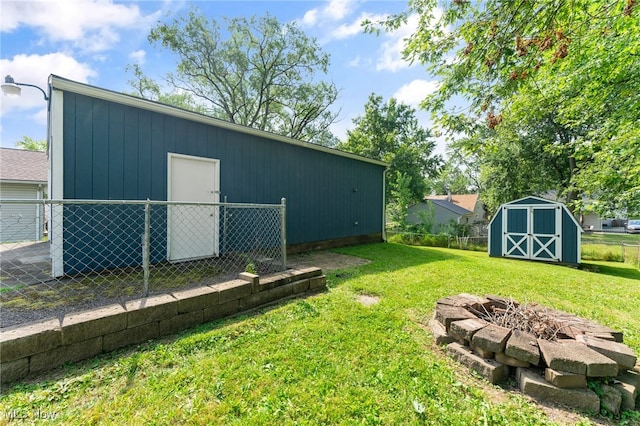 view of yard with a shed and a fire pit