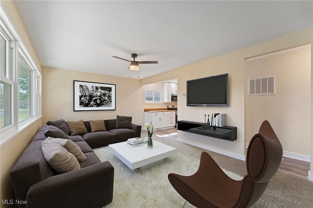 living room featuring light wood-type flooring and ceiling fan