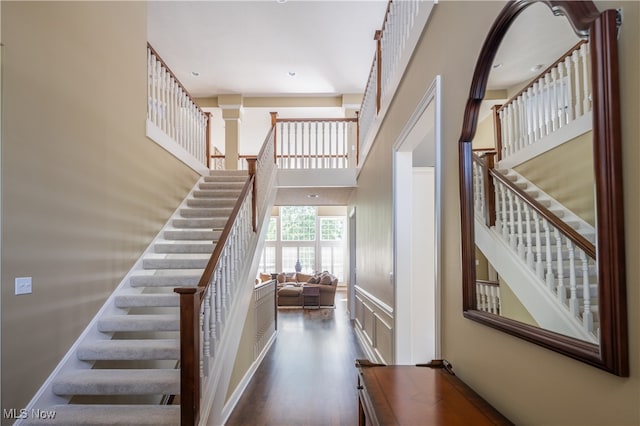 stairway featuring decorative columns and a towering ceiling