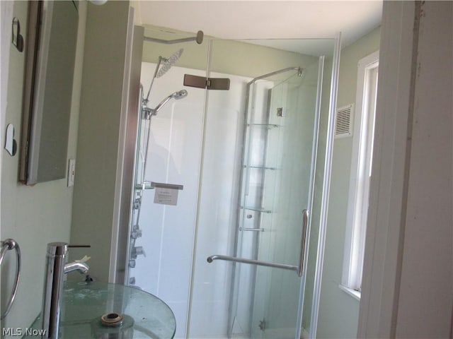 bathroom with a shower stall, visible vents, and a sink