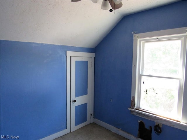 bonus room with baseboards, ceiling fan, a textured ceiling, and lofted ceiling