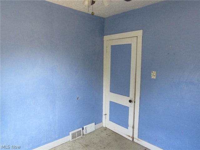 carpeted spare room featuring a ceiling fan, baseboards, and visible vents