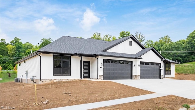 view of front of home with a garage and central air condition unit