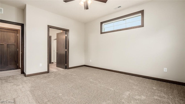 unfurnished bedroom featuring light carpet, connected bathroom, and ceiling fan