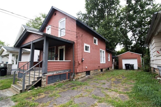 view of home's exterior featuring a garage, an outbuilding, and covered porch