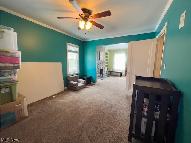 interior space featuring carpet flooring, ceiling fan, ornamental molding, and a fireplace