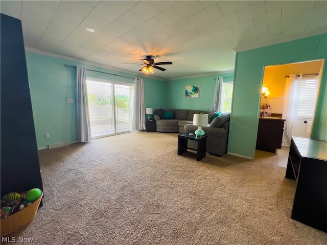 carpeted living room featuring ceiling fan and ornamental molding