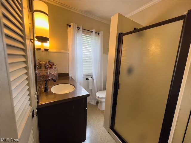 bathroom featuring vanity, toilet, a shower with shower door, and ornamental molding