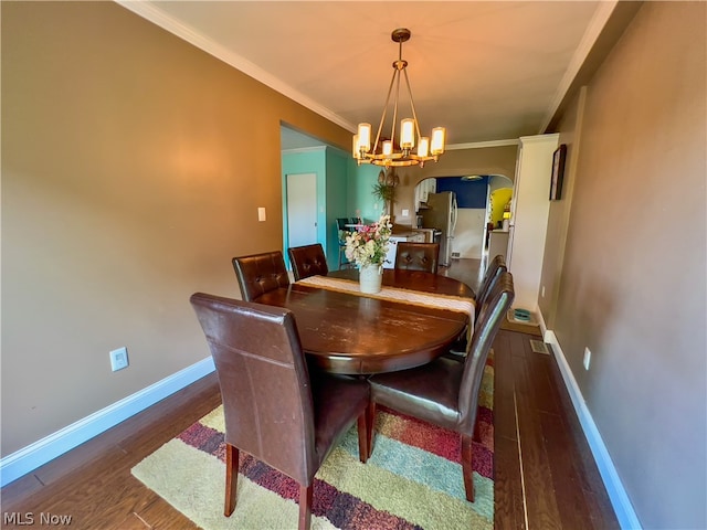 dining area with a notable chandelier, dark hardwood / wood-style flooring, and crown molding