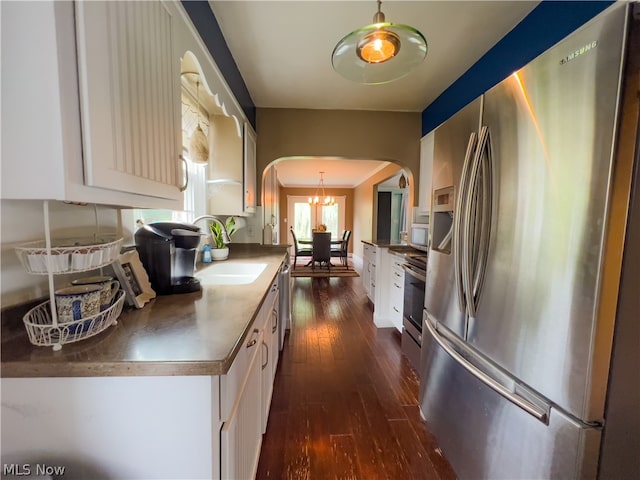 kitchen with appliances with stainless steel finishes, dark hardwood / wood-style flooring, crown molding, sink, and white cabinetry