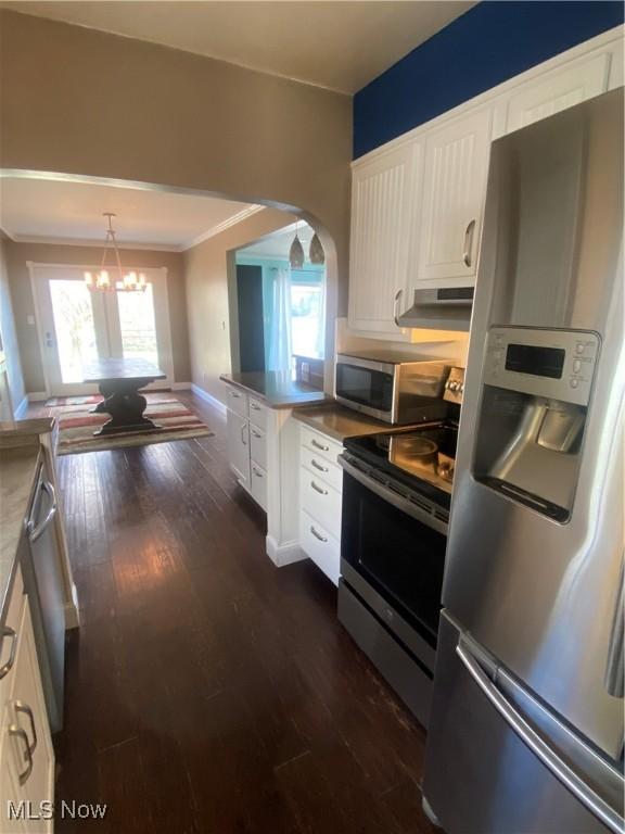 kitchen featuring crown molding, white cabinetry, stainless steel appliances, and dark wood-type flooring