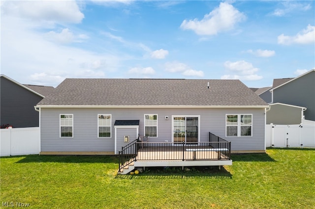 rear view of property with a yard and a wooden deck