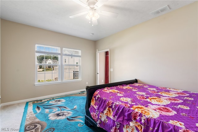 bedroom with carpet floors, a textured ceiling, and ceiling fan