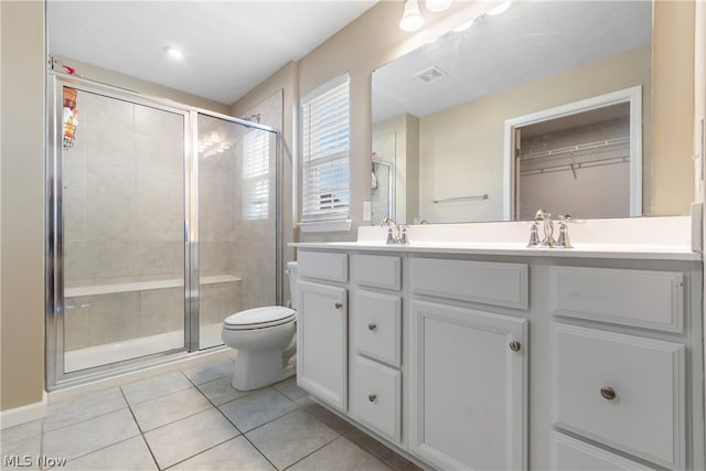 bathroom with tile patterned flooring, dual vanity, toilet, and an enclosed shower