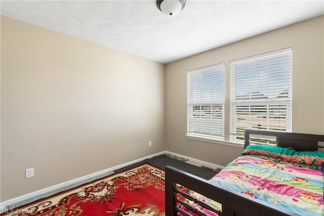 carpeted bedroom with multiple windows and a textured ceiling