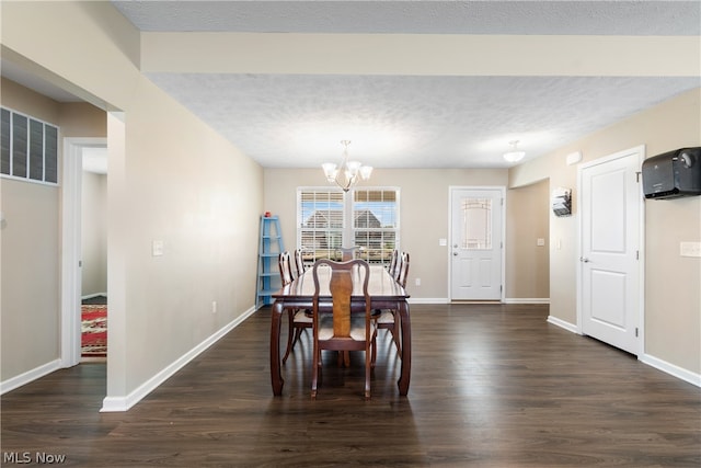 dining space with a notable chandelier, a textured ceiling, and dark wood-type flooring