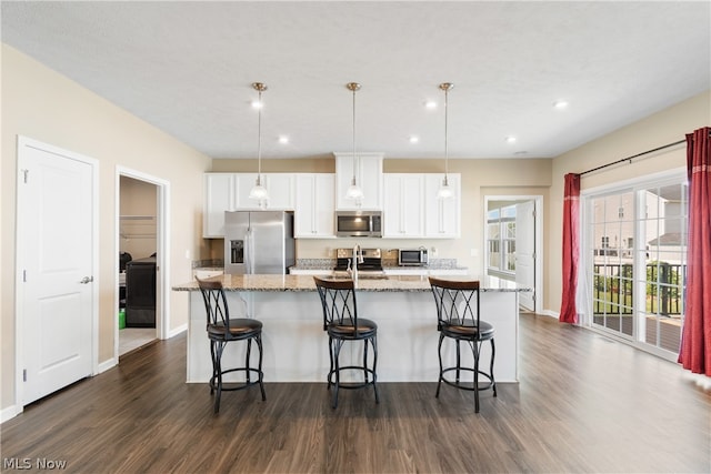 kitchen featuring white cabinetry, dark hardwood / wood-style flooring, an island with sink, light stone countertops, and appliances with stainless steel finishes