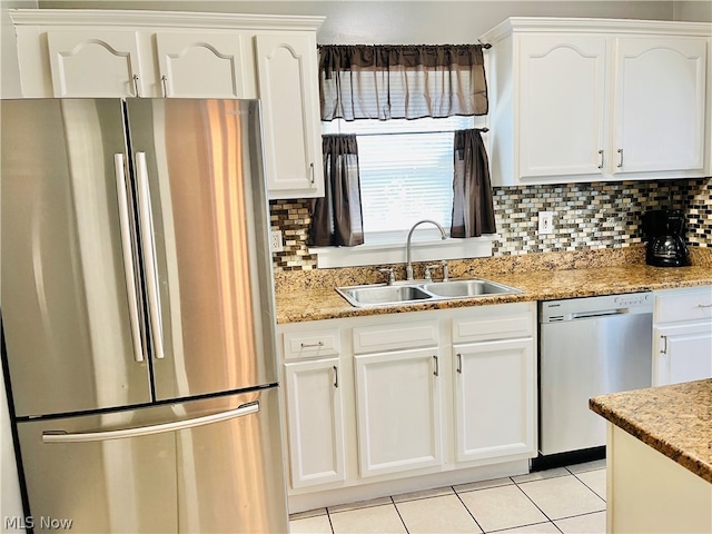 kitchen featuring light tile patterned flooring, sink, backsplash, stainless steel appliances, and white cabinets