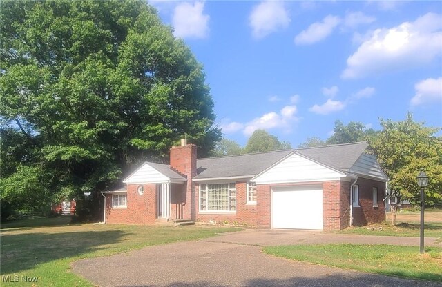 ranch-style house with a garage and a front yard