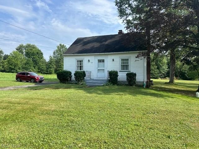 rear view of property featuring a lawn