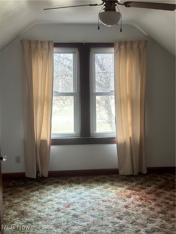 additional living space featuring vaulted ceiling, ceiling fan, and dark colored carpet