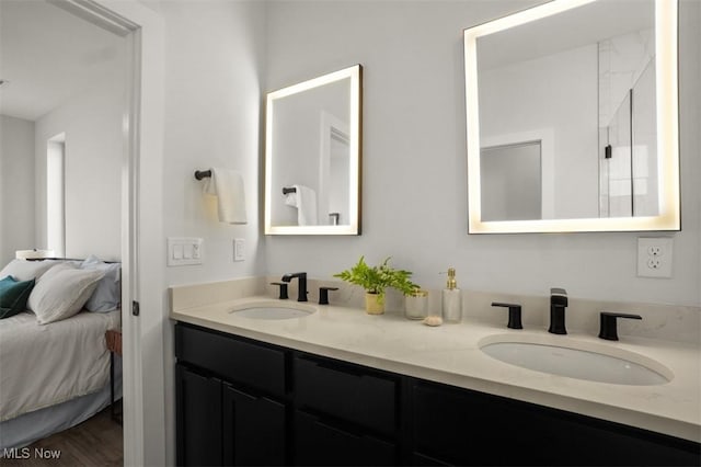 ensuite bathroom with double vanity, a sink, and ensuite bath