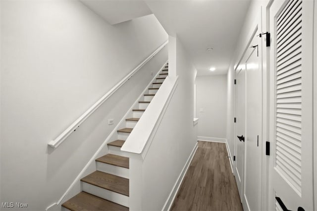 stairs with wood finished floors, baseboards, and recessed lighting
