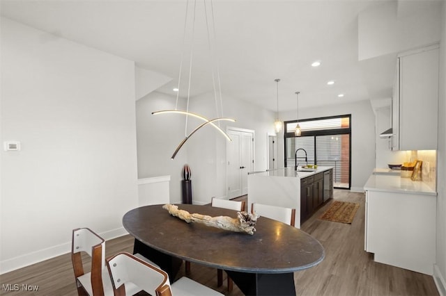 dining area featuring recessed lighting, light wood-style floors, and baseboards