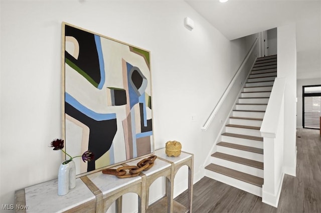 staircase featuring baseboards and wood finished floors