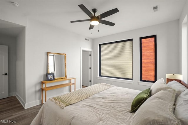 bedroom featuring visible vents, baseboards, a ceiling fan, and wood finished floors